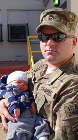 Army Staff Sgt. Joe Murray holds his 3-week-old baby at his Fort Campbell, Ky., battalion headquarters.Photo by Hope Murray