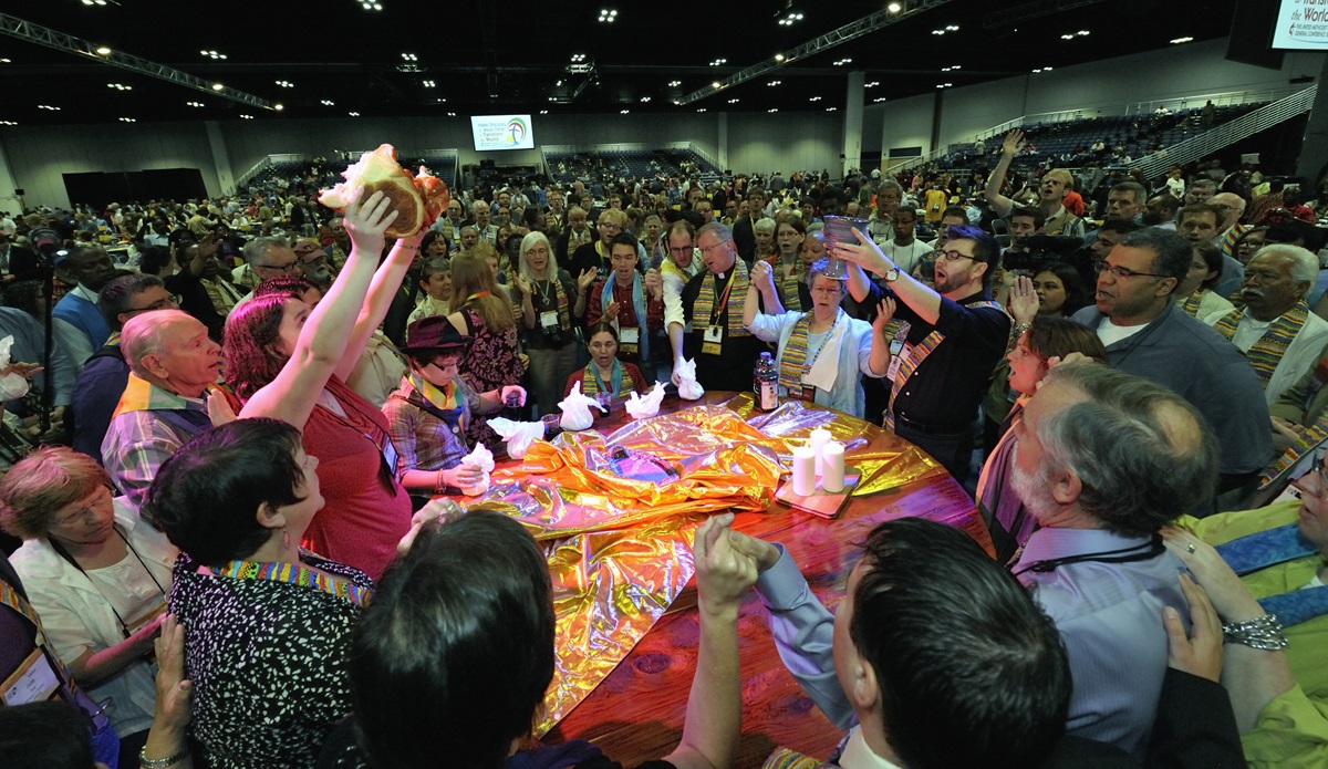 Dozens of demonstrators demanding a more inclusive church took over the floor of a May 3 session of the 2012 United Methodist General Conference in Tampa, Fla. They held Communion around the center table and sang songs, causing the presiding bishop to suspend the morning session. 2012 file photo by Paul Jeffrey, UMNS