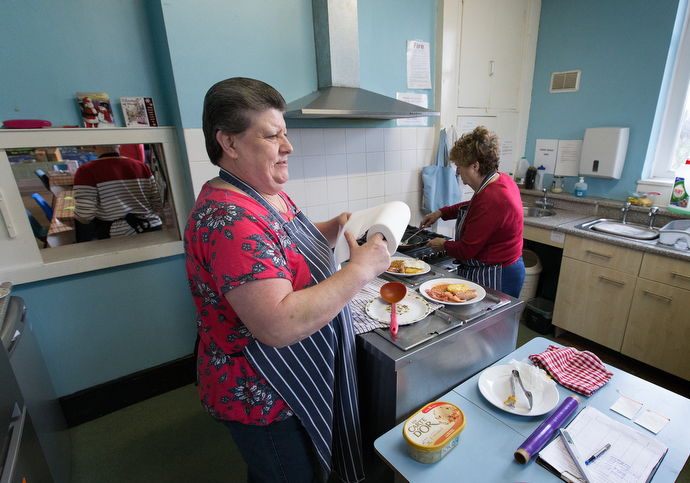 Maureen Dooley (center) and Mary Weldon prepare meals for the community café. Photo by Mike DeBose, UMNS.