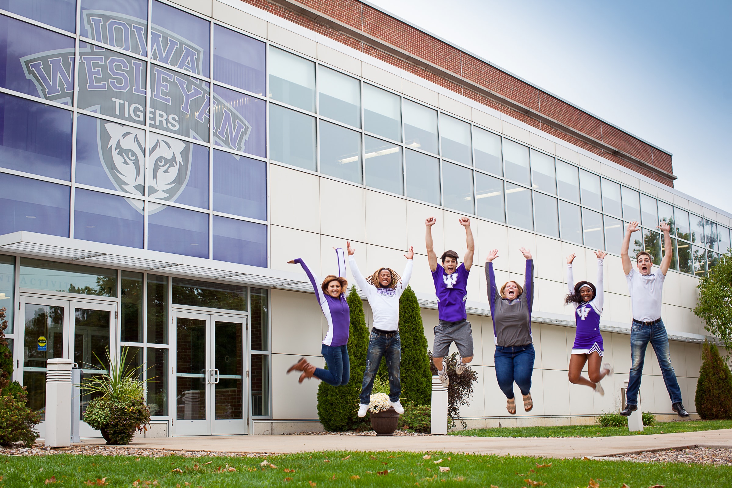 Students from Iowa Wesleyan University jump in this campus shot in Mount Pleasant, Iowa. Photo courtesy of Iowa Wesleyan University.