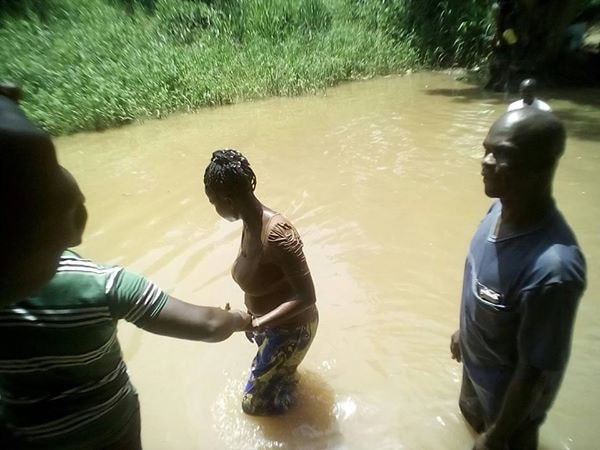 Aishatou Ndiaye en train de se faire baptisée le 20 Avril 2019. A côté se trouve le conducteur Laïc Faustin Gassimbala (en noir). Photo de Petula Dockpa, UM News.
