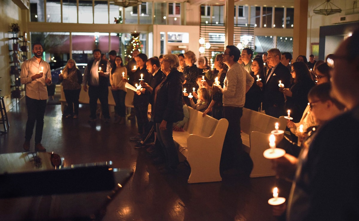 O Rev. Will Choate (à esquerda) ajuda a liderar os fiéis a cantar “Silent Night” à luz de velas na véspera de Natal de 2018 na Igreja Metodista Unida Argenta, em North Little Rock, Arkansas. A crescente congregação e outras pessoas através da conexão Metodista Unida estão se preparando para fazer com que os visitantes se sintam bem-vindos. Foto cedida por Igreja Metodista Unida.