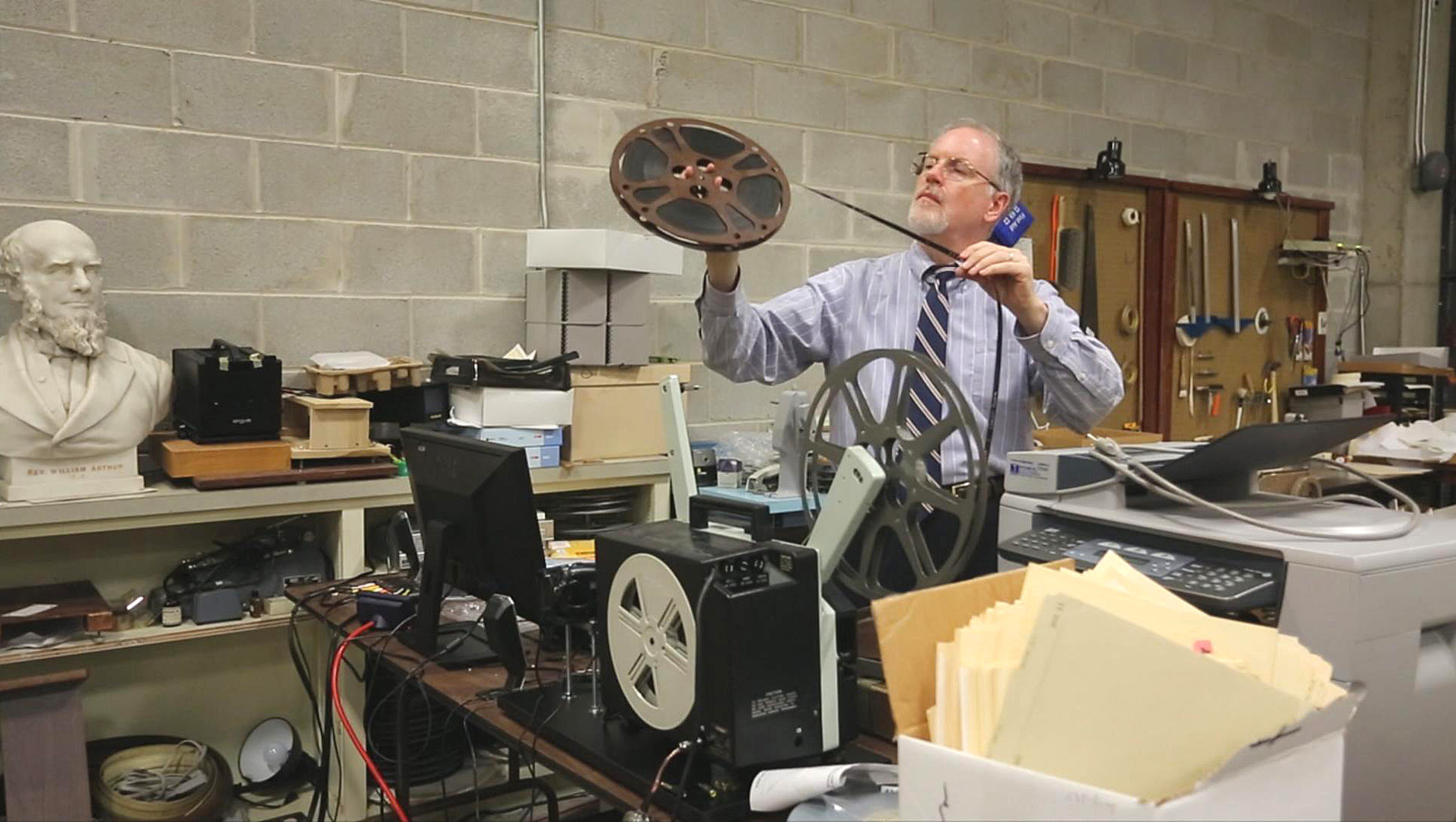 L. Dale Patterson, archivist-records administrator at the United Methodist Commission on Archives and History, examines film, one of thousands of carefully filed items at the agency housed on the campus of Drew University in Madison, New Jersey. A 2013 file photo by Kathleen Barry, UM News. 