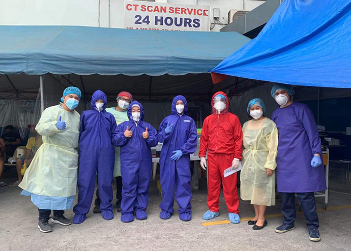 Les agents en première ligne de l'Hôpital Méthodiste Uni Mary Johnston de Manille, aux Philippines, placent la foi au-dessus de la peur quand ils se préparent à un nouveau quart de travail pour traiter les patients atteints du COVID-19, a déclaré le Dr Glenn Roy V. Paraso (en rouge). L'hôpital dispose de six tentes de COVID-19 installées sur le parking de l'hôpital. Photo avec l'aimable autorisation du Dr Glenn Roy V. Paraso.