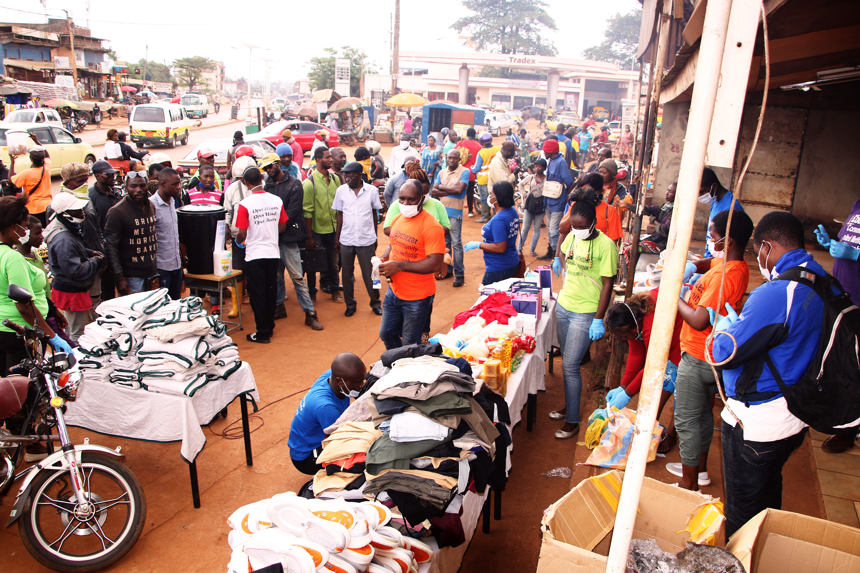 Ndobe Ebeneza Mosima, pasteur de l'église Méthodiste Unie Ebenezer de Yaoundé (en orange au centre) s’adresse à la population venue assister à la campagne de sensibilisation contre le COVID-19. Photo de Collette Ndpbe, UM News.