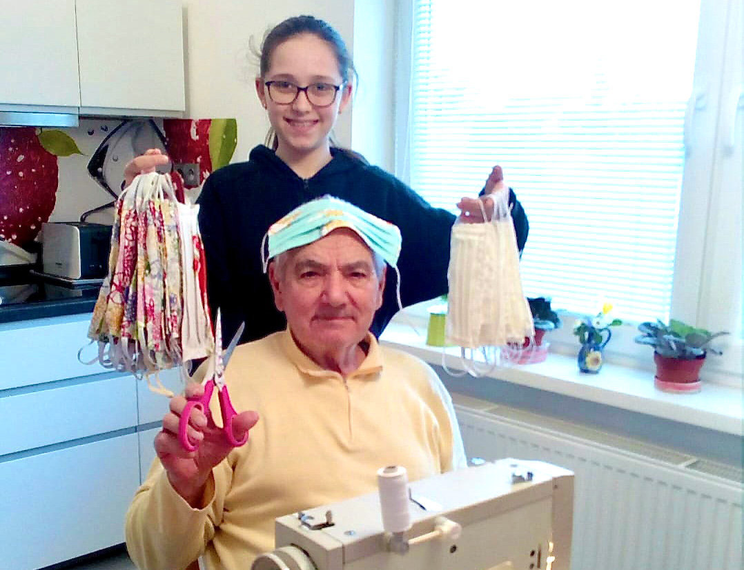 Michal Tagaj, 82, is a member of the United Methodist Church in Sered, Slovakia, and has made more than 80 masks with his sewing machine. His granddaughter Emma shows off some of the masks, which are being distributed to church members and people in high-risk groups in several different towns. Photo courtesy of the Central Conference of Central and Southern Europe.