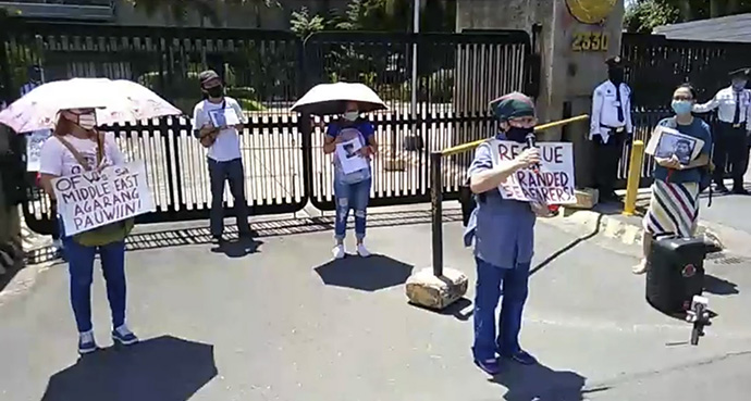 The Rev. Mariesol Villalon, program manager for anti-human trafficking and migrant ministry in the Manila Episcopal Area speaks to a crowd. In the background holding the umbrella is Eden Joy Agagad, Sabado’s sister.  Screenshots from the Facebook page of Migrante International.