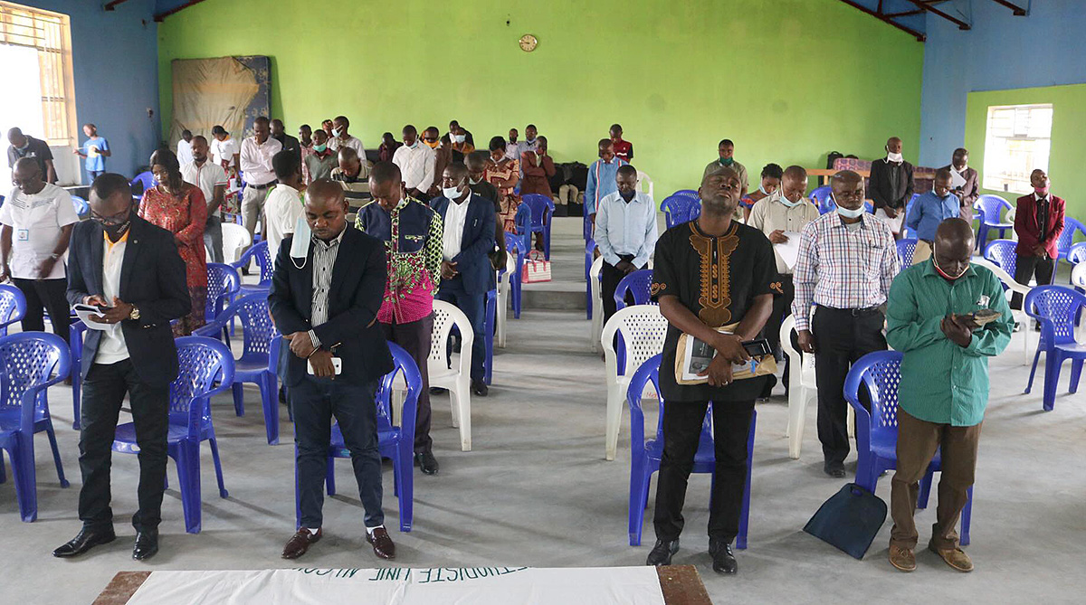 Membros da Conferência Anual de Kivu, reunidos em Goma, Congo, oram pelos 19 civis mortos em um massacre em Mamove. Entre os mortos estavam seis Metodistas Unidos que viajavam para uma reunião da igreja. Foto de Philippe Kituka Lolonga, Notícias MU.