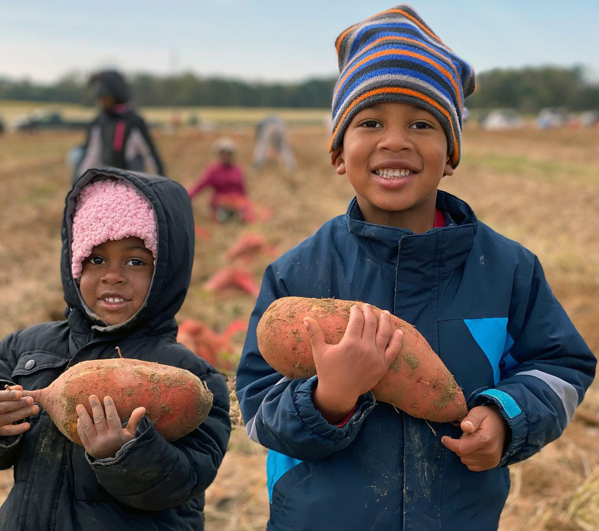 Olivia (left) and Judah Brown hold sweet potatoes at First Fruits Farm in Louisburg, N.C. Owned by their parents Jason and Tay Brown, the farm supplies produce to Society of St. Andrew, which is helping get food to needy citizens. Photo courtesy of the Browns.