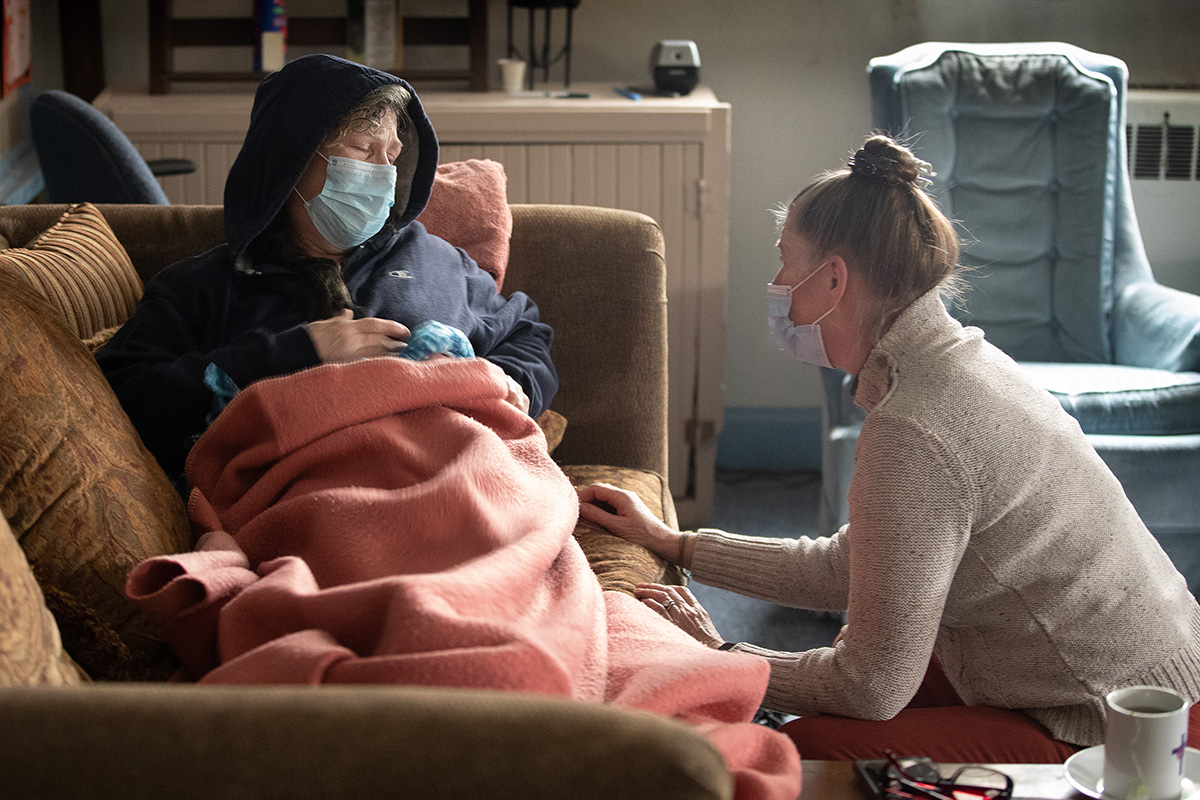 A Revda. Ruth Marsh (à direita) conforta Angi Rogers, uma hóspede do abrigo diurno na Igreja Metodista Unida Trinity em Idaho Falls, Idaho. Rogers não estava se sentindo bem e Marsh a acomodou em uma sala de aula da escola dominical para descansar um pouco. “Todos aqui cuidam de mim e uns dos outros”, disse Rogers. Foto de Mike DuBose, Notícias MU.