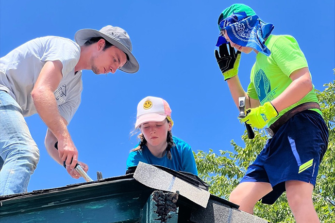 Youth from First United Methodist Church in Dallas help repair a roof in 105-degree heat during their recent summer mission trip to San Antonio. Nick Janzen (left), construction manager for Blueprint Ministries, works with Vivian Winston and Wesley Stoker of the Dallas church. Photo by Anna Bundy-Hagler. 