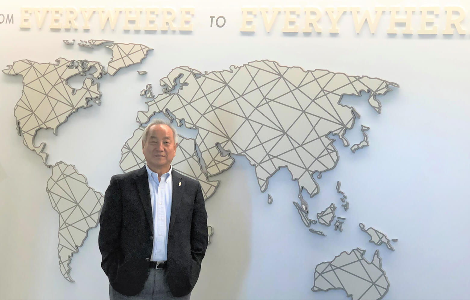 정희수 감독이 2022년 9월 29일 한인목회강화협의회 연례 회의 중 “모든 곳에서 모든 곳으로”라는 세계선교부 구호와 세계지도가 붙여진 세계선교부 사무실 앞에 서 있다. 사진, 김응선 목사, 연합감리교뉴스.