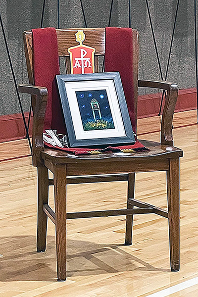 En una silla vacía, cubierta con una estola episcopal, la Obispa Lizzette Gabriel Montalvo de la Iglesia Metodista de Puerto Rico, colocó el cuadro obsequiado por MARCHA a la Obispa Minerva Carcaño, como reconocimiento a su legado ministerial en favor de la misión de la denominación en general, y en especial al servicio de los sectores más empobrecidos y marginados de la iglesia y la sociedad. La Obispa Carcaño fue reconocida en ausencia con la silla vacía, como símbolo de protesta del caucus a la suspensión de sus funciones episcopales y a la separación de la vida de la iglesia, mientras es sometida a un juicio por varias denuncias en su contra, que se llevará a cabo en septiembre de 2023.