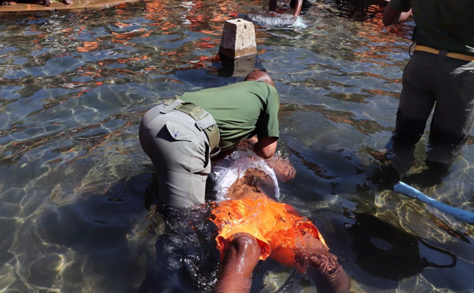 El capellán Jefat Zhou sumergió a un recluso durante un evento de bautismo celebrado por La IMU el 28 de julio en la prisión de máxima seguridad de Chikurubi en Harare, Zimbabue. Cientos de reclusos fueron bautizados como parte del ministerio de extensión de la iglesia en la prisión. Foto de Prudence Choto, Prisión de Máxima Seguridad de Chikurubi. 