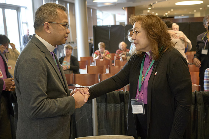 United Methodist Bishop Carlo A. Rapanut speaks with Bishop Minerva G. Carcaño following the announcement of the jury verdict on Sept. 22 in Glenview, Illinois. Carcaño was found not guilty on all four charges against her. Rapanut, bishop of the Desert-Southwest Conference and secretary of the Western Jurisdiction College of Bishops, welcomed Carcaño, who had been suspended, back into the college. Photo by Paul Jeffrey, UM News.