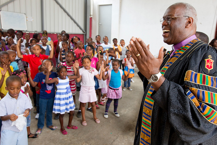 O bispo Metodista Unido Warner H. Brown (à direita) agradece pela apresentação em sua homenagem pelas criancas da Igreja Metodista Unida Central em Luanda, Angola. Após sua eleição para o episcopado em 2000, ele e os colegas bispos recém -eleitos de Angola criaram uma parceria onde igrejas da área episcopal de Brown forneceriam apoio salarial aos clerigos no Leste de Angola. Suas congregações geralmente não conseguiam pagar seu salário total. Foto de arquivo de 2012 por Mike Dubose, Noticias da UM.