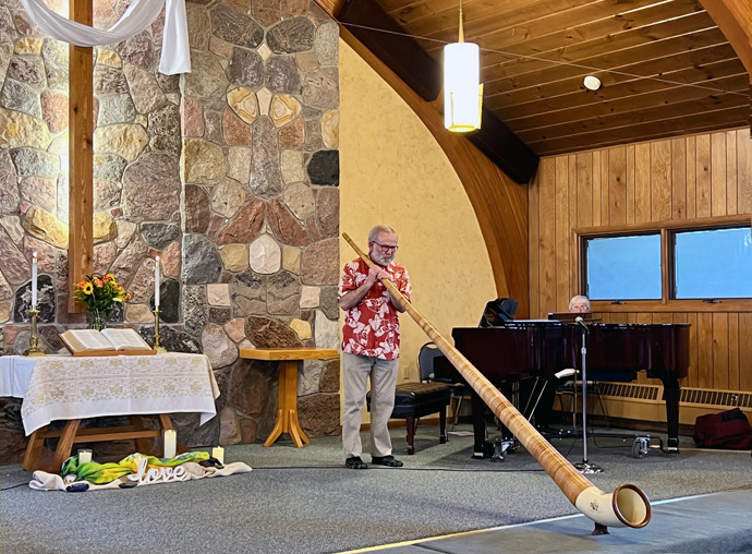 Paul Watson demonstra o corno alpino como parte da Música para Missões, apresentada pela Igreja Metodista Unida da Columbia Falls, Mont., para beneficiar a parceria do Leste de Angola. Além do apoio ao salário do pastor em andamento, o legado que as conferências legadas de Yellowstone e Rocky Mountain ajudaram a criar um programa agrícola na Missão de Quéssua na Conferência de Leste de Angola. Foto cedida pelo Rev. Jared Stine.