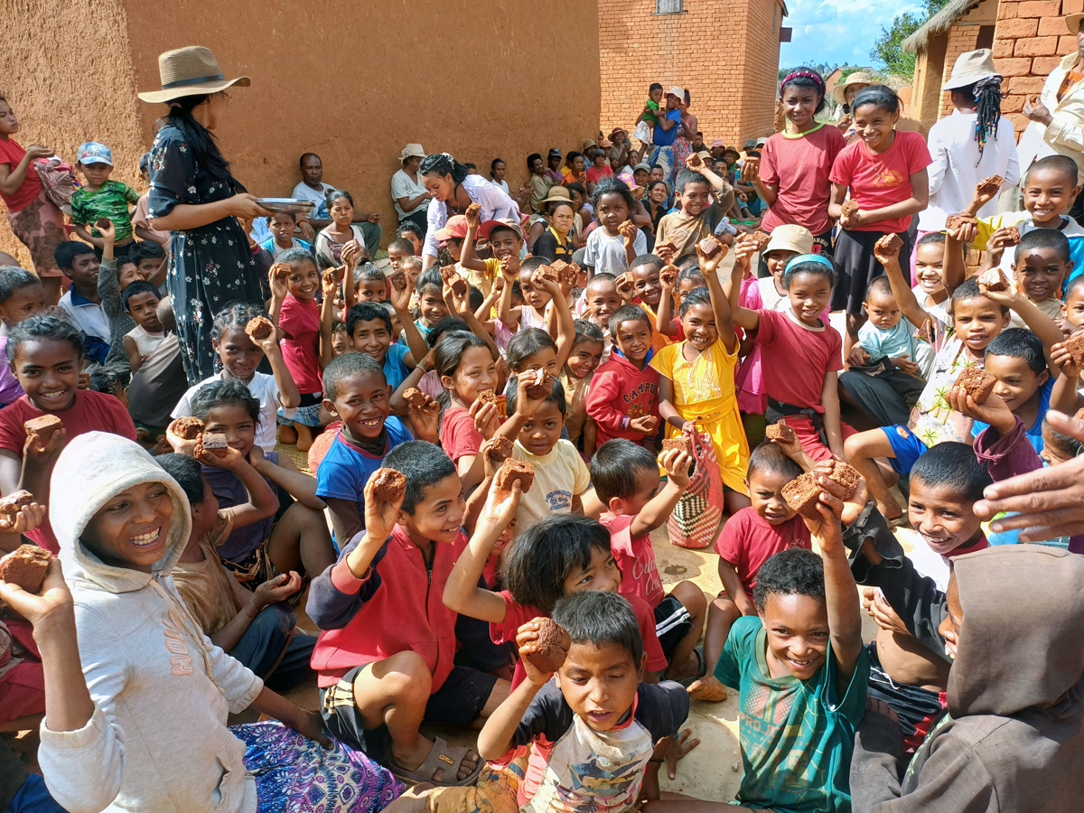 Des enfants et des jeunes montrent fièrement le gâteau qu’ils ont reçu des visiteurs de l’Église Méthodiste Unie d’Ambodifasika à Faratanjona, Madagascar. La communauté fait face à des pénuries alimentaires dues au changement climatique et à d’autres facteurs qui ont réduit la production agricole dans la région. Photo d’Esdras Rakotoarivony, UM News. 