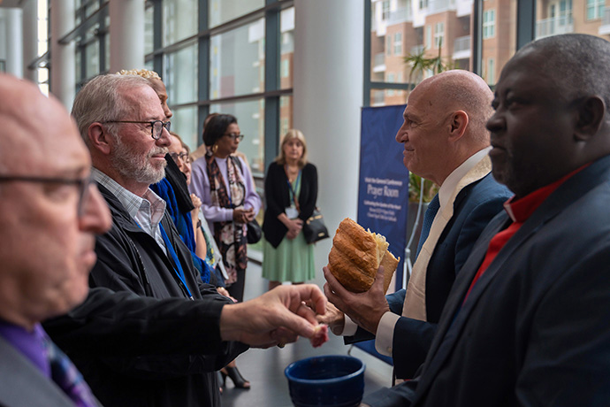 L'Évêque John Schol, qui dirige les Conférences du Grand New Jersey et de l'Est de la Pennsylvanie, et l'Évêque de la Région du Nigéria John Wesley Yohanna servent les éléments pendant le service de communion de la chapelle de prière de l'Upper Room lors de la Conférence Générale Méthodiste Unie à Charlotte, N.C. Photo par James Lee, Conférence du Grand New Jersey.