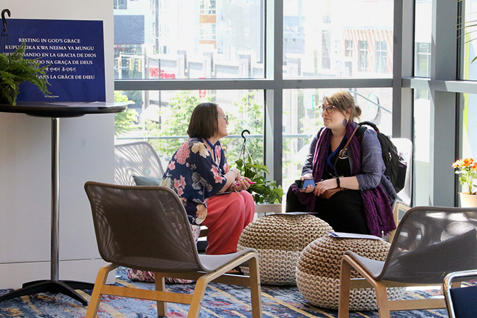 Susan Haffner-Hüm (à gauche), directrice spirituelle de l'Upper Room, et Sarah Veles, de la Conférence de Caroline du Nord Occidentale, discutent dans l'un des huit espaces de méditation prévus dans la salle de prière du Charlotte Convention Center, lors de la Conférence Générale Méthodiste Unie. Photo par le Rév. Thomas Kim, UM News.
