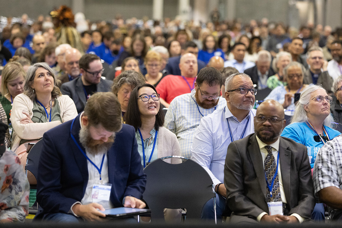 Os visitantes da Conferência Geral Metodista Unida em Charlotte, N.C., assistem aos procedimentos em monitores de vídeo suspensos. Foto de Mike DuBose, Notícias da MU.