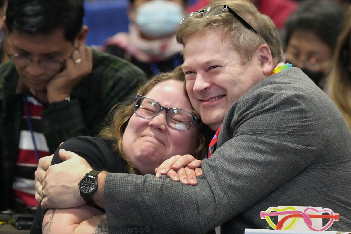 Kaleigh Corbett and Thomas Lank of the Greater New Jersey Conference embrace after General Conference delegates voted on May 2 to eliminate the longtime assertion in the denomination’s Social Principles that “the practice of homosexuality… is incompatible with Christian teaching.” The legislative assembly is meeting in Charlotte, N.C., through May 3. Photo by Larry McCormack, UM News.