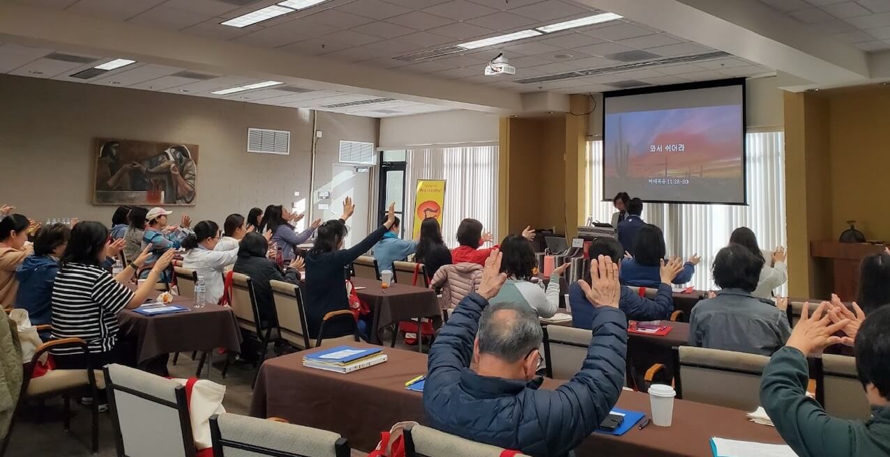 <사랑하는 나의 딸에게>라는 주제로 2024년 3월 4일부터 8일까지 열린 제2회 사모들을 위한 영성형성아카데미에서 참석자들이 함께 손을 들고 기도하고 있다. 사진 제공, 영성형성아카데미.