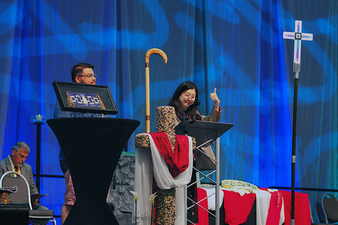 The Rev. Jee Hae Song (right) of the Upper New York Conference presents legislation at the 2024 Upper New York Annual Conference in Syracuse, N.Y., to enact a parental leave policy that adapts the model legislation for New York’s expanded Family and Medical Leave Act. Photo courtesy of the Upper New York Conference.