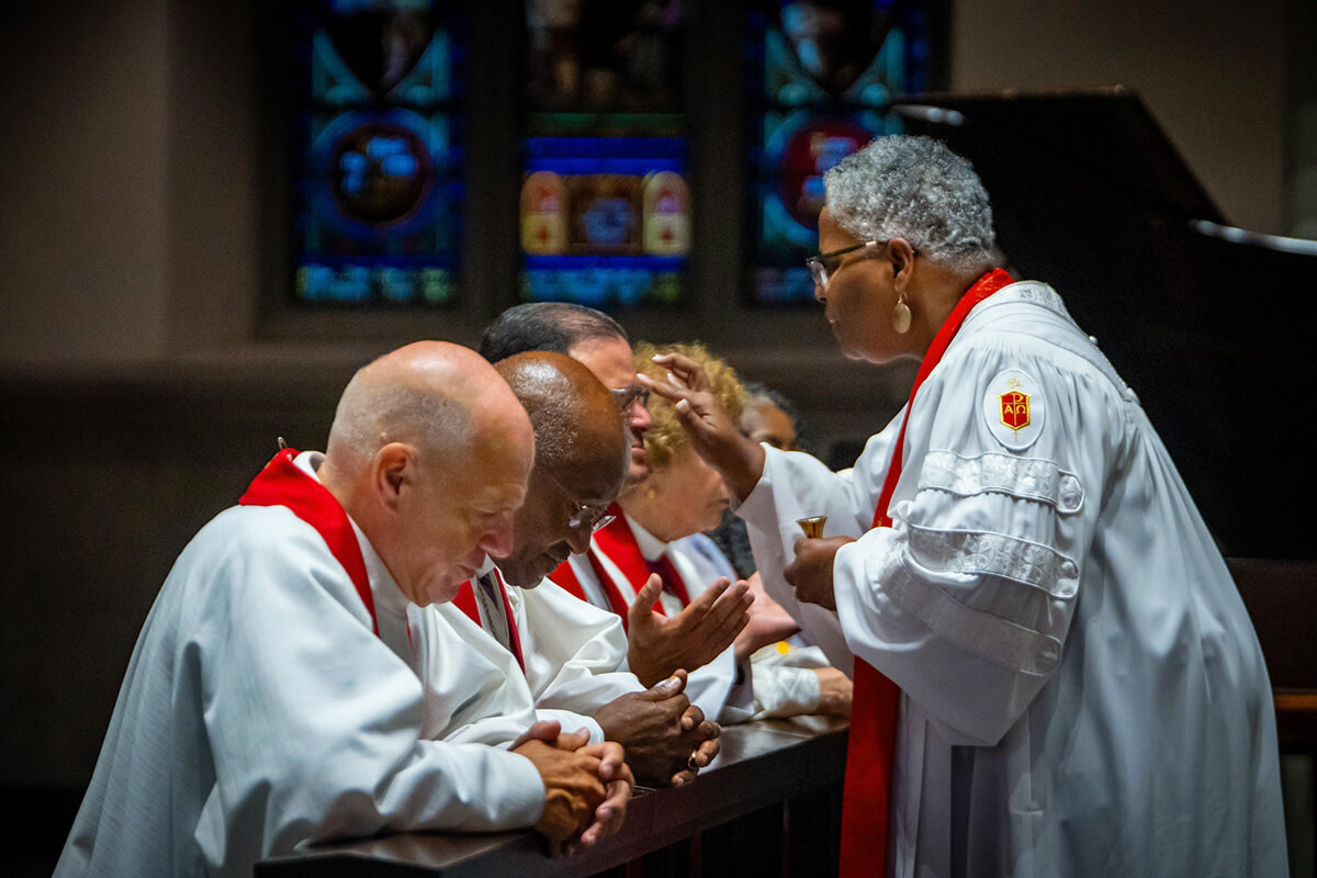 Bishop LaTrelle Easterling, who leads the Baltimore-Washington and Peninsula-Delaware conferences,  anoints the forehead of Bishop Héctor A. Burgos-Núñez during the Northeastern Jurisdictional Conference held July 10-12 in Pittsburgh. To the left is Bishop John R. Schol and Bishop Marcus Matthews. Photo by James Lee, courtesy of the United Methodists of Eastern Pennsylvania Facebook page.