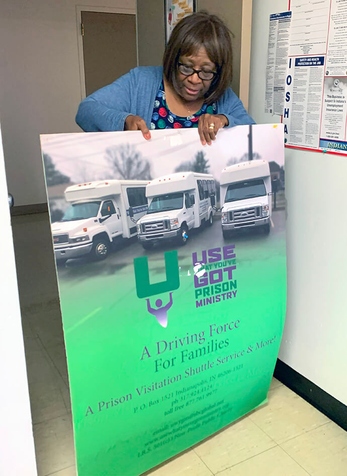 At North United Methodist Church in Indianapolis, Cecelia Whitfield holds a poster for the Use What You’ve Got Prison Ministry that she started to provide rides for families visiting loved ones in prison. Photo by Joey Butler, UM News.