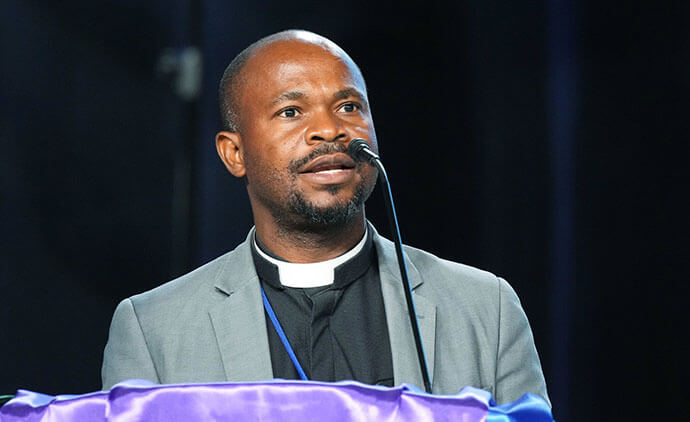 The Rev. Ande Emmanuel gives a report to delegates during the 2024 United Methodist General Conference on May 2 in Charlotte, N.C. Photo by Larry McCormack, UM News.
