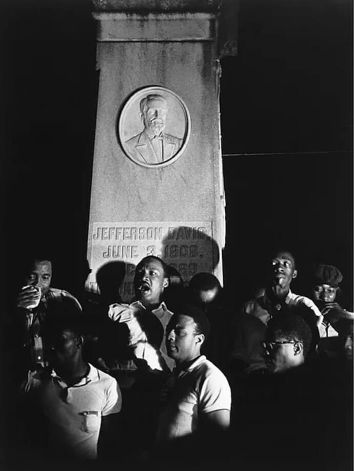 The Rev. Martin Luther King Jr. (center, back), politician and civil rights activist Andrew Jackson Young Jr. (center, front) and members of the civil rights movement protest in front of the Jefferson Davis memorial at the March Against Fear rally in Grenada, Miss., June 14, 1966. Photo by Charmain Reading, an artist hired by the Student Nonviolent Coordinating Committee to document Black protests in the South in front of Confederate memorials. Photo courtesy of Capitol Hill United Methodist Church.