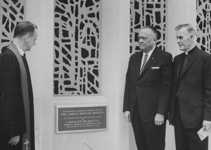 J. Edgar Hoover director del FBI, al centro junto a una placa con la que le dedicaron un gran vitral en la Iglesia Metodista Capitol Hill, hoy llamada Iglesia Metodista Unida Capitol Hill, el 26 de junio de 1966. También estan los reverendos Edward B. Lewis a la izquierda, pastor de la iglesia, y Frederick Brown Harris a la derecha, capellán del Senado. Está previsto que el vitral se vuelva a dedicar el 29 de septiembre para restar importancia a la conexión con Hoover, cuya antigua casa se encontraba en donde ahora está el estacionamiento de la iglesia. Foto cortesía de la Iglesia Metodista Unida Capitol Hill.