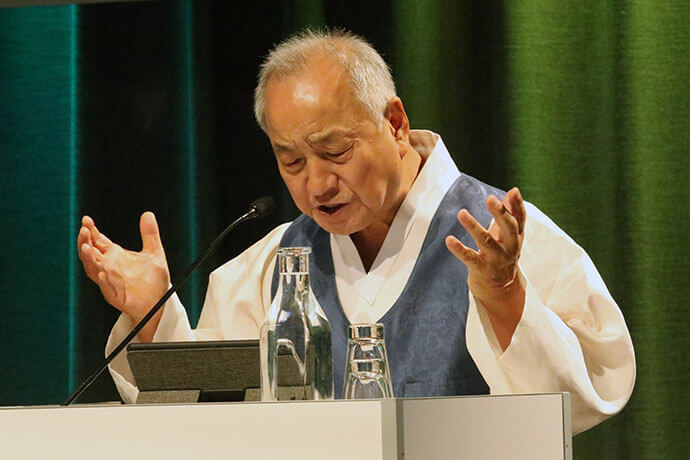 United Methodist Bishop Hee-Soo Jung prays for God to grant peace and remember those suffering from the effects of wars around the world and from the division of the Korean Peninsula during Korea Peace Night held on Aug. 15 at the World Methodist Conference in Gothenburg, Sweden. Photo by the Rev. Thomas E. Kim, United Methodist News.