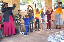 Florence Kachingwe (à gauche, en jupe rose), présidente de la Class of 81 Charitable Foundation, chante et danse avec les enfants du Fairfield Children's Home, un foyer pour enfants affilié à l'Église Méthodiste Unie à Mutare, au Zimbabwe. La fondation, créée par d'anciens élèves du Lycée Méthodiste Uni Hartzell, a fait don de nourriture et d'autres fournitures à l'école. Photo de Tafadzwa Gumbochuma. Florence Kachingwe (à gauche, en jupe rose), présidente de la Class of 81 Charitable Foundation, chante et danse avec les enfants du Fairfield Children's Home, un foyer pour enfants affilié à l'Église Méthodiste Unie à Mutare, au Zimbabwe. La fondation, créée par d'anciens élèves du Lycée Méthodiste Uni Hartzell, a fait don de nourriture et d'autres fournitures à l'école. Photo de Tafadzwa Gumbochuma.