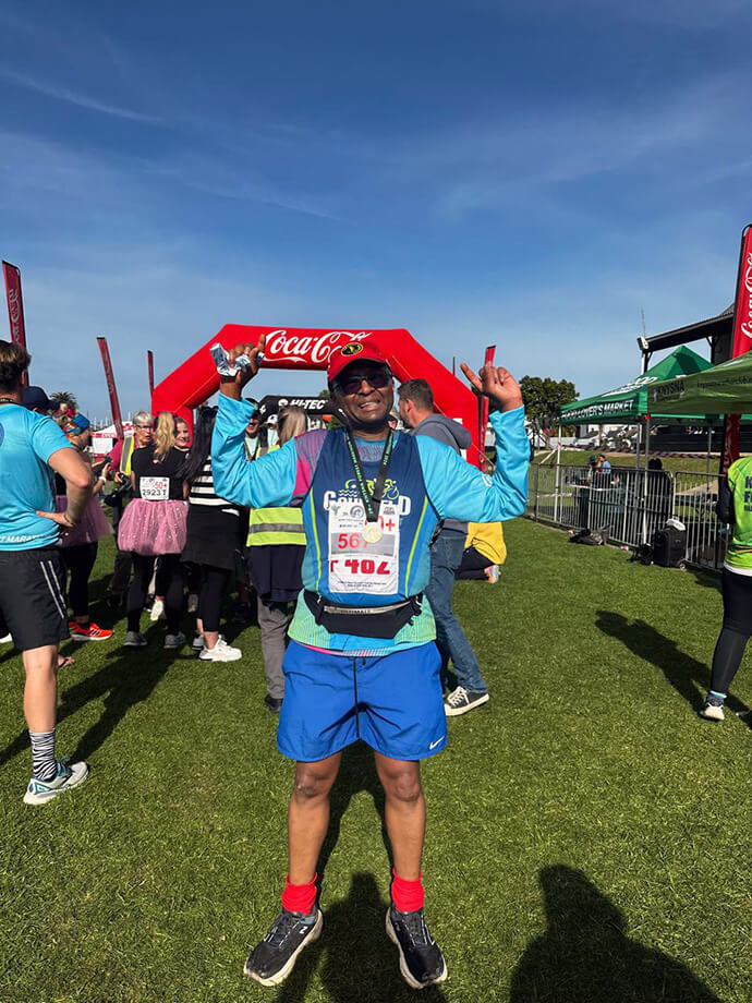 Dr. Ralph Nhiwatiwa, a South Africa-based physician who is also the organizing treasurer of The Class of 81 Charitable Foundation, celebrates after completing a marathon June 22 in Knysna, South Africa. Nhiwatiwa ran to raise money for the foundation’s efforts to feed less-privileged children. Photo by Melody Nhiwatiwa.