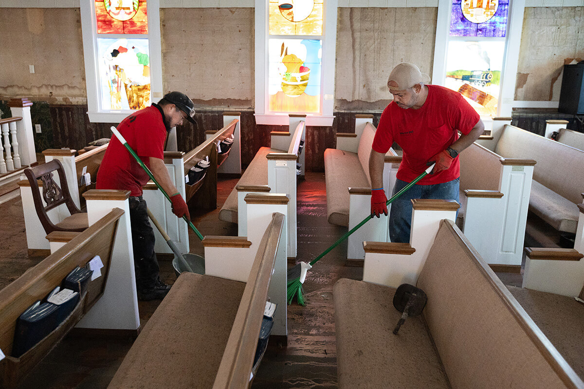 Elias Torres (left) and Vinicius Maciel clean up flood damage from Hurricane Helene at Cedar Key (Fla.) United Methodist Church. Church members are beginning the long, slow recovery following Helene’s devastating storm surge and flooding in the southeastern U.S. Conferences are busy supporting survivors. Photo by Mike DuBose, UM News.