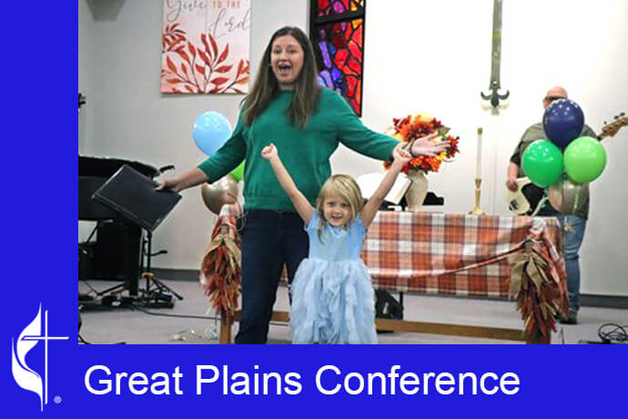 With the help of Monticello United Methodist Church pastor Matt Ozment's 5-year-old daughter, the Rev. Bailey Amtower celebrates the 15th anniversary of LifeBridge Church in Shawnee, Kan. Photos by David Burke, Great Plains Conference.