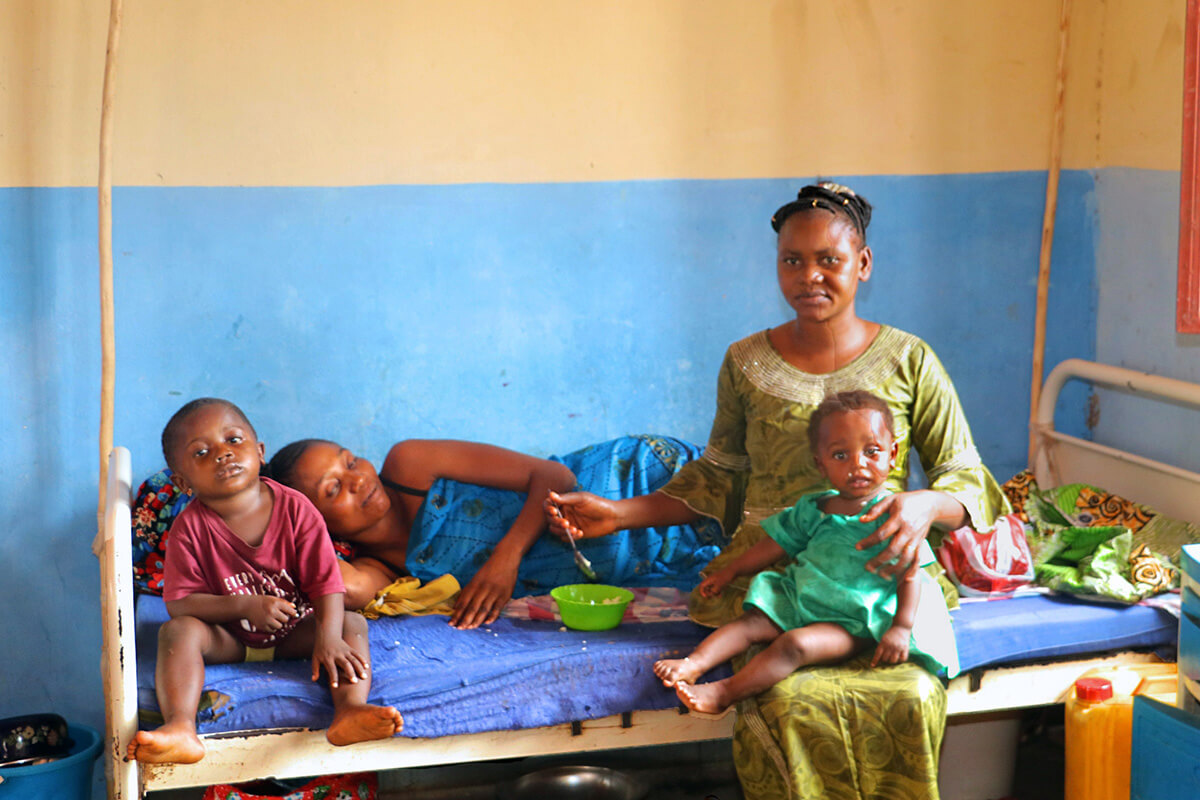 Pierre Kenga (non illustré) a parcouru plus de 80 kilomètres depuis le village de Dikwadjondo, dans la province de Sankuru, jusqu'à l'Hôpital Général de Tunda, affilié à l'Église Méthodiste Unie, à Tunda, au Congo, en compagnie de sa femme (assise) et de sa sœur (couchée). L'hôpital attire de plus en plus de patients de régions éloignées. Photo par Chadrack Tambwe Londe, UM News.