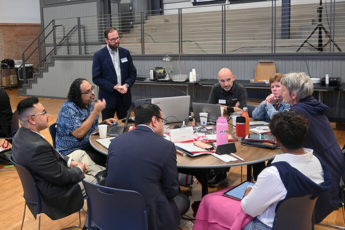 David Scott (standing), senior director of mission theology and strategic planning for the United Methodist Board of Global Ministries, listens to members of the Connectional Table discuss colonialism Oct. 24 during orientation training in Dallas. Photo by Jim Patterson, UM News.