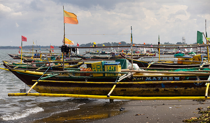 Idled fishing boats line the beach in the Mozon II neighborhood in Rosario after Typhoon Carina caused three oil tankers to sink in Manila Bay, contaminating the fishing grounds that provide the area’s livelihood. Photo by Mike DuBose, UM News.