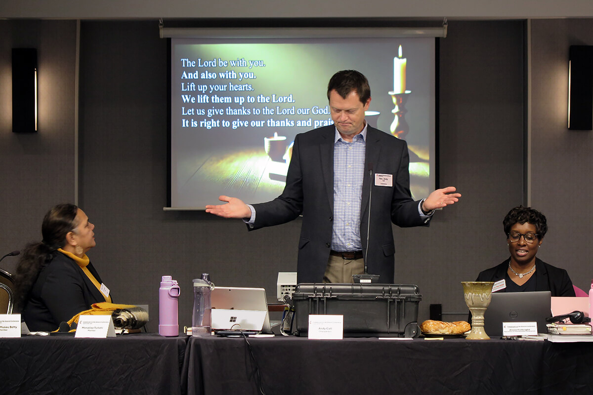 El Rev. Andy Call, presidente de la comisión de la Conferencia General, ayuda a dirigir la Sagrada Comunión durante el culto de apertura el 19 de noviembre en la reunión de la comisión celebrada en Charlotte, Carolina del Norte. Sentada a la izquierda de Call está Monalisa Tui'tahi vicepresidenta de la comisión, y el Rev. Aleze M. Fulbright a la derecha, el nuevo secretario de la Conferencia General. Durante la reunión, la comisión comenzó los preparativos para la próxima reunión de la principal asamblea legislativa de La Iglesia Metodista Unida, prevista para 2028. Foto de Heather Hahn, Noticias MU. 