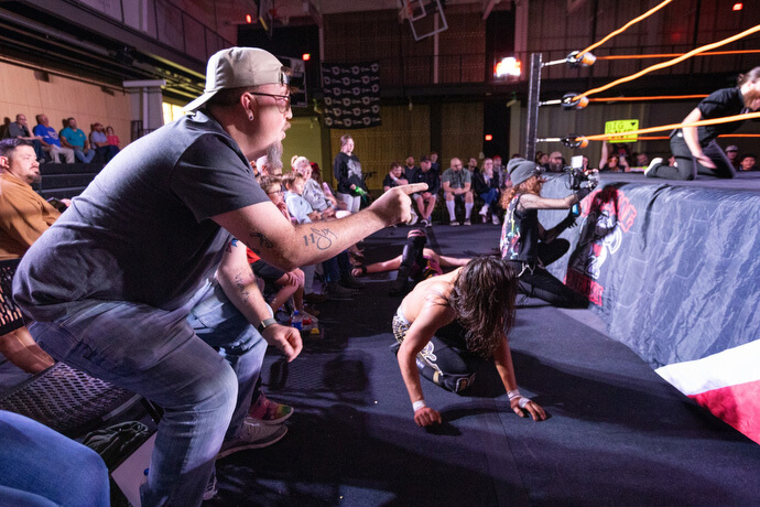 El Rev. Steven Barber anima a los luchadores mientras la acción sale del ring y llega a la pista el 2 de noviembre en el Centro de Eventos de Priceville, Alabama. Barber, pastor de la Iglesia Metodista Unida Neel en Hartselle, Alabama se desempeña como capellán no oficial de la comunidad de lucha libre profesional. 