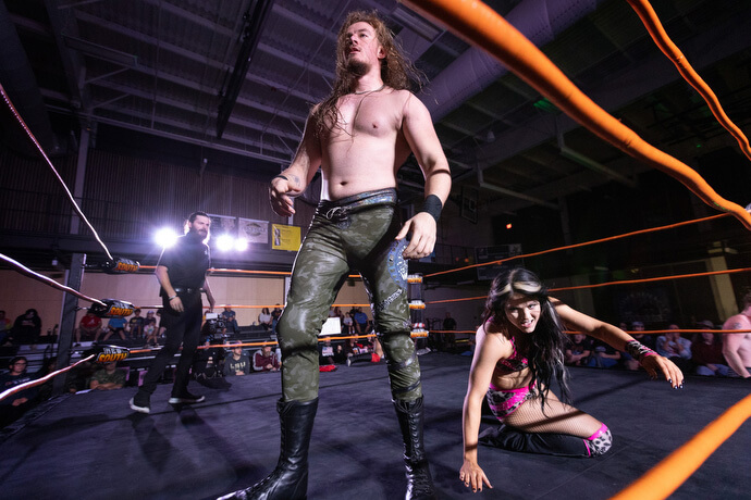 Los luchadores profesionales The Wall, de pie, y Kenzie Paige comparten el ring durante un combate del 2 de noviembre en el Centro de Eventos de Priceville, Alabama.