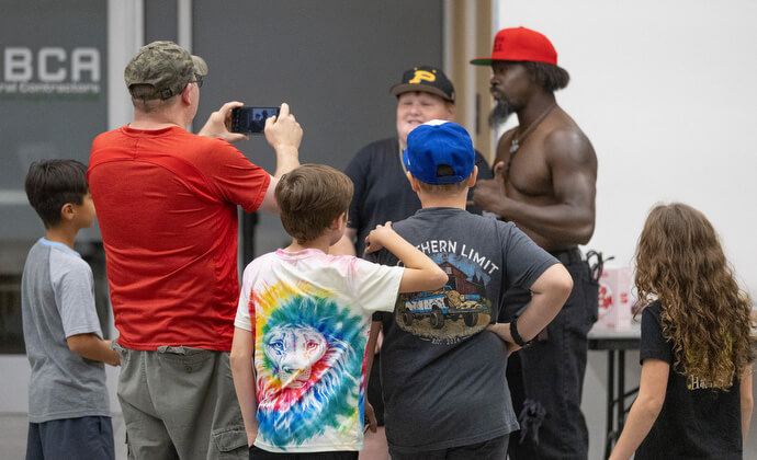 Fanáticos hacen fila para recibir autógrafos y fotografiarse con el luchador Trevor Aeon durante el intermedio de un partido en el Centro de Eventos de Priceville, Alabama. 