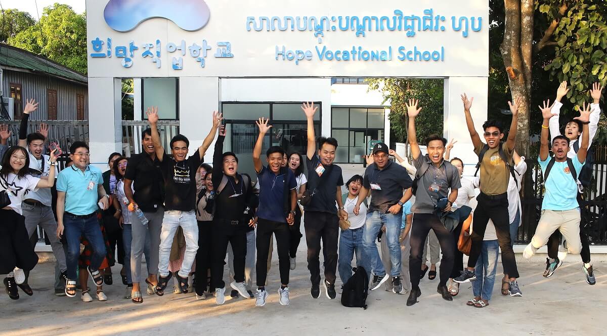 2024년 11월 4일, 글로벌 청년 지도자 훈련 프로그램인 어센드( ASCEND) 참석자들과 강사들이 프놈펜에 있는 희망직업학교 앞에서 점프를 하고 있다. 사진, 김응선(Thomas E. Kim), 연합감리교뉴스. 