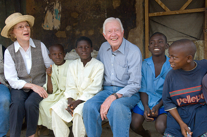 Former U.S. President Jimmy Carter and former First Lady Rosalynn Carter sit with young victims of schistosomiasis disease, during a trip to Nasarawa, Nigeria, in February 2007, to assess Carter Center health programs. Photo courtesy of The Carter Center.