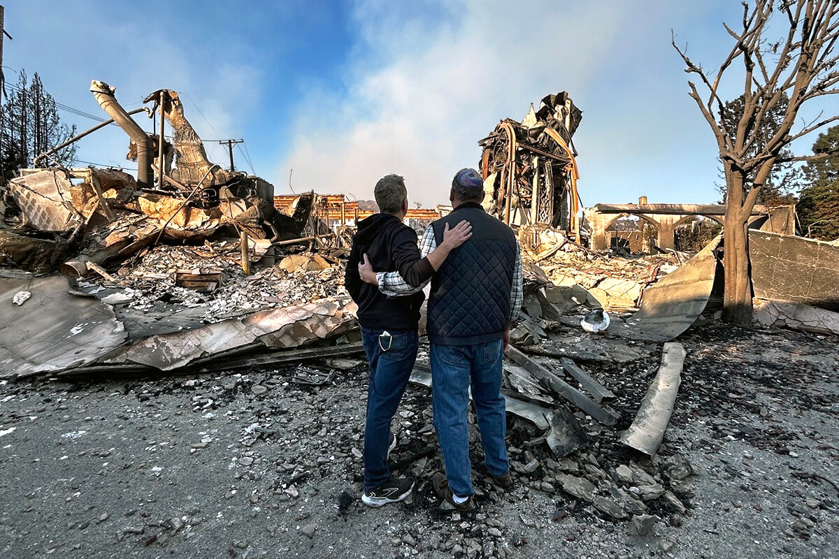 The Rev. John Shaver (left) and his friend, Rabbi Mark Blazer, look out at the rubble left of Community United Methodist Church in Pacific Palisades, Calif., where Shaver is pastor. The community of Pacific Palisades was mostly destroyed by the Palisades wildfire. Photo courtesy of Shaver, California-Pacific Conference.