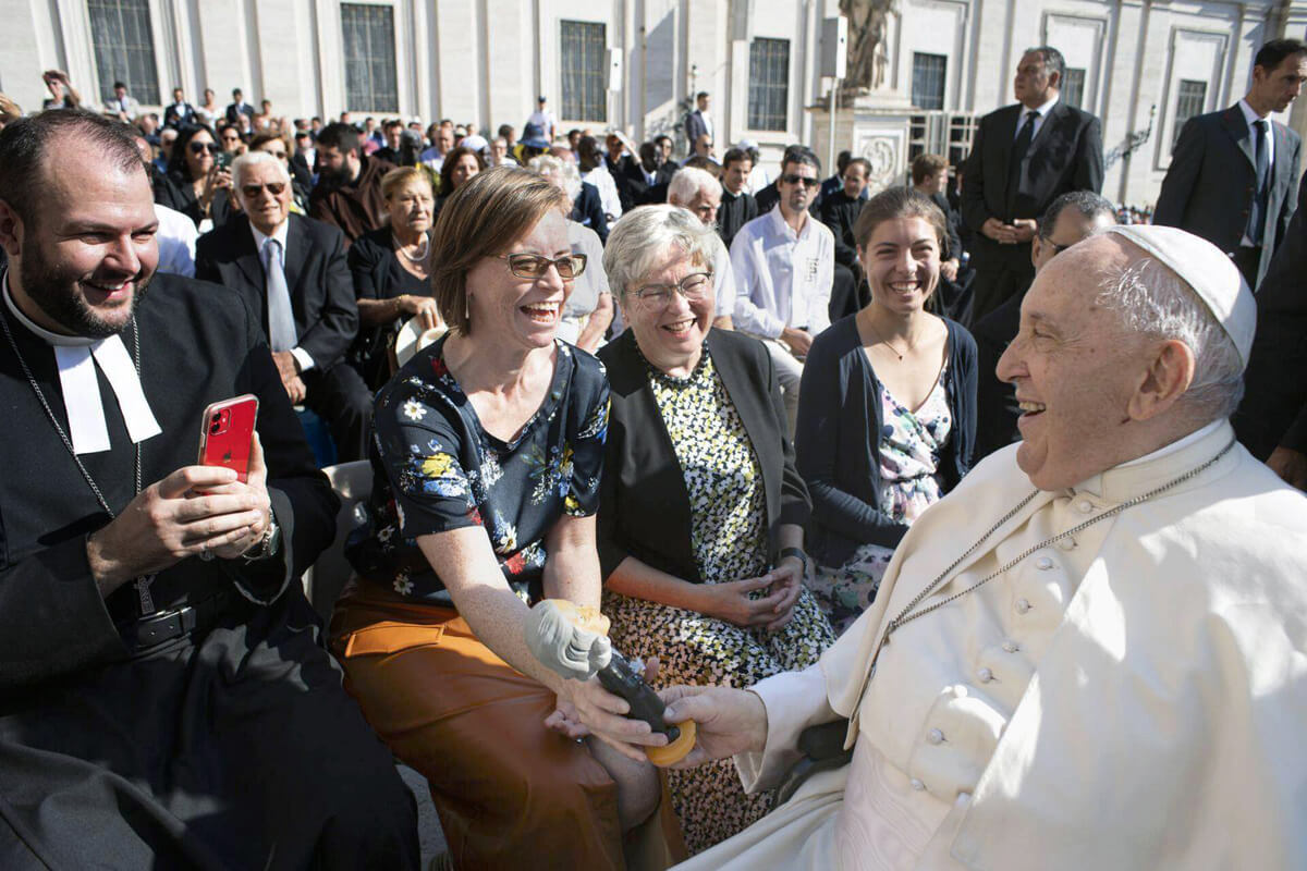 Ashley Boggan, top executive of the United Methodist Commission on Archives and History, gifts Pope Francis, head of the Catholic Church, with a John Wesley bobblehead on Sept. 6, 2023, while in Italy for the European Methodist Historical Conference. Seated from left are the Rev. Matthew Laferty, director of the Methodist Ecumenical Office Rome; Boggan, Ulrike Schuler with the United Methodist Board of Higher Education and Ministry, and Lara Herrmann, a student and Schuler’s granddaughter. File photo courtesy of Vatican Media.