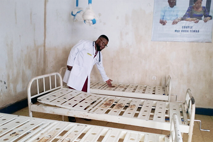 Dr. Jimmy Kasongo, medical director at United Methodist Irambo Health Center in Bukavu, Congo, surveys damage after armed men attacked the hospital in mid-February. Damage included broken windows and gates and the destruction of testing kits, mattresses and hospital equipment. Photo by Philippe Kituka Lolonga, UM News.